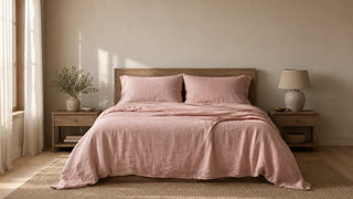 Bed styled with soft pink linen bedding in a neutral bedroom.