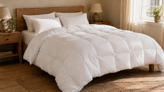 White down duvet arranged on a sunlit wooden bed